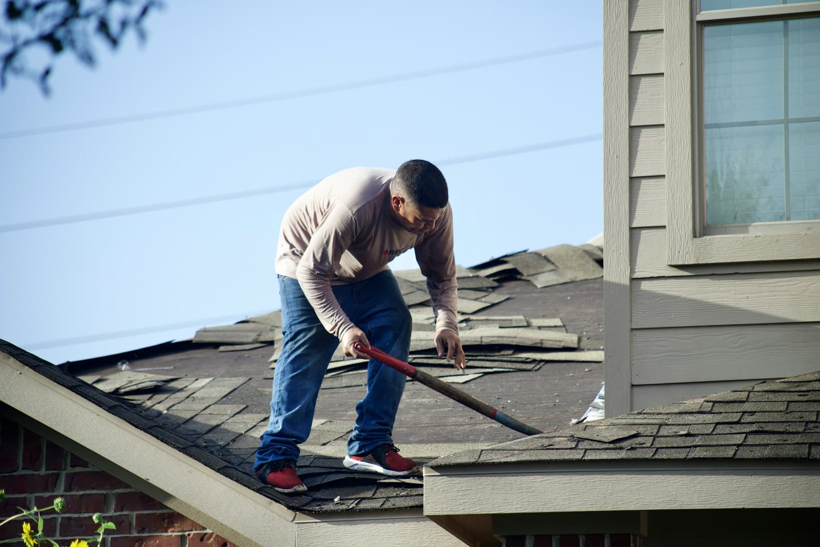 Roofer sealing flashing around a chimney with fresh sealant